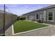 Low-maintenance backyard featuring artificial grass and a neutral color palette with string lights at 2354 E Lieber Pl, Phoenix, AZ 85024