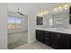 Bathroom with double sinks, dark cabinetry, and a view to the bedroom and shower area at 2354 E Lieber Pl, Phoenix, AZ 85024