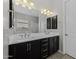 Bathroom with double vanity, dark cabinets, and a view to the bathtub and shower area at 2354 E Lieber Pl, Phoenix, AZ 85024