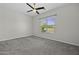 Standard-sized bedroom with carpet, ceiling fan and a view from a window at 2354 E Lieber Pl, Phoenix, AZ 85024