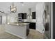This modern kitchen has dark cabinets, granite countertops, stainless steel appliances, and decorative lighting at 2354 E Lieber Pl, Phoenix, AZ 85024