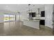 A modern kitchen with dark cabinetry, granite countertops, and stainless steel appliances opens to the living room at 2354 E Lieber Pl, Phoenix, AZ 85024