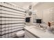 Bathroom featuring a white sink vanity, modern fixtures, decorative wall baskets and stylish striped shower curtain at 266 N Piedra Way, Mesa, AZ 85207