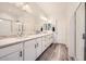 Elegant bathroom featuring a double sink vanity with granite countertops, framed mirrors, and a glass-enclosed shower at 266 N Piedra Way, Mesa, AZ 85207