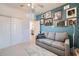 Cozy bedroom features colorful wall art, neutral carpet, a ceiling fan and a comfortable seating area with a sofa at 266 N Piedra Way, Mesa, AZ 85207