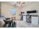 Bright bedroom used as an office with a ceiling fan, large window, and built-in desk area and a comfortable couch at 266 N Piedra Way, Mesa, AZ 85207