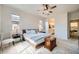 Light and airy main bedroom with a ceiling fan, neutral walls, and ample natural light from multiple windows and a view to bathroom at 266 N Piedra Way, Mesa, AZ 85207