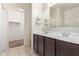 Bathroom featuring double sinks, dark wood cabinets, and a walk in closet at 29109 N Fire Agate Rd, San Tan Valley, AZ 85143
