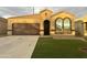Charming single-story home featuring a two-car garage, well-maintained lawn, and inviting arched windows at 29109 N Fire Agate Rd, San Tan Valley, AZ 85143