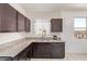 Kitchen featuring granite countertops, dark wood cabinets, and stainless-steel dishwasher at 29109 N Fire Agate Rd, San Tan Valley, AZ 85143
