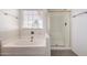 Bright bathroom featuring a tub and glass shower with white tile surround at 3165 W Golden Ln, Chandler, AZ 85226