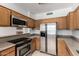 Close-up view of the kitchen with stainless appliances, granite countertops, and wood cabinetry at 3165 W Golden Ln, Chandler, AZ 85226
