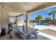 Inviting covered patio with wood dining set overlooking a pristine pool and lush landscaping at 3169 E Eleana Ln, Gilbert, AZ 85298