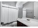 Bathroom with a white toilet and sink, a wood cabinet, a mirror, and a shower with a white curtain at 3169 E Eleana Ln, Gilbert, AZ 85298