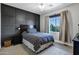 Stylish bedroom with a black wood accent wall, ceiling fan, and a window with natural light at 3169 E Eleana Ln, Gilbert, AZ 85298