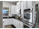 Bright kitchen boasts white cabinetry, stainless steel appliances, dark countertops and backsplash at 3169 E Eleana Ln, Gilbert, AZ 85298