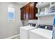 Well-lit laundry room with modern washer and dryer, overhead cabinets and a window at 3169 E Eleana Ln, Gilbert, AZ 85298