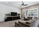 Cozy living room with shiplap wall, large TV, plush sectional sofa, and shuttered windows at 3169 E Eleana Ln, Gilbert, AZ 85298