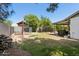 Wide backyard featuring mature trees, a garden, and a covered patio area at 3736 W Angela Dr, Glendale, AZ 85308