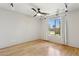 Bright bedroom featuring hardwood floors, a ceiling fan, track lighting, and a window view to the home's exterior at 3736 W Angela Dr, Glendale, AZ 85308