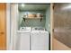 Laundry room featuring side-by-side washer and dryer with overhead shelving for storage and supplies at 3736 W Angela Dr, Glendale, AZ 85308