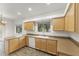 Well-lit kitchen featuring wood cabinets, stainless sink, tile flooring, and bright natural light at 39016 N Habitat Cir, Cave Creek, AZ 85331