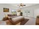 Bright main bedroom with wooden bedframe, ceiling fan, and sliding doors to balcony at 39016 N Habitat Cir, Cave Creek, AZ 85331