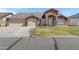Charming single-story brick home with a three-car garage and well-maintained front yard at 4030 E Meadow Creek Way, San Tan Valley, AZ 85140