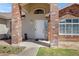 Close-up of the home's brick entryway with a white front door and stylish address plaque at 4030 E Meadow Creek Way, San Tan Valley, AZ 85140