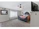 This main bedroom offers a ceiling fan, carpeted flooring and a TV with a grey bedframe at 4030 E Meadow Creek Way, San Tan Valley, AZ 85140