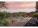 Backyard with desert landscaping and a patio area, against a backdrop of a colorful sunset at 41602 N Congressional Dr, Phoenix, AZ 85086