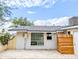 A view of the back of this home showing a tile patio, windows, and a storage area at 4202 E Sahuaro Dr, Phoenix, AZ 85028