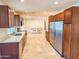 Spacious kitchen with stainless steel appliances, wooden cabinets, and tile floors at 4202 E Sahuaro Dr, Phoenix, AZ 85028