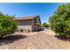 View of the backyard including a pool, desert landscaping, and the home's exterior at 44468 W Eddie Way, Maricopa, AZ 85138