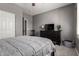 Neutral bedroom with a ceiling fan, a window, a dresser and a gray textured basket at 44468 W Eddie Way, Maricopa, AZ 85138