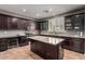 Modern kitchen with dark wood cabinetry, stainless steel appliances, and a granite island for added convenience at 44468 W Eddie Way, Maricopa, AZ 85138