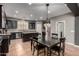 Kitchen with stainless steel appliances, an island, wood cabinets, granite countertops, and adjacent dining table at 44468 W Eddie Way, Maricopa, AZ 85138