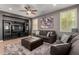 Comfortable living room with gray sofas, ottoman, ceiling fan, and a media center for entertainment at 44468 W Eddie Way, Maricopa, AZ 85138