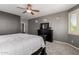Comfortable main bedroom featuring a ceiling fan, television and neutral carpet at 44468 W Eddie Way, Maricopa, AZ 85138