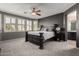 Comfortable main bedroom featuring a ceiling fan, shuttered windows and neutral carpet at 44468 W Eddie Way, Maricopa, AZ 85138