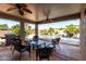 Covered patio with outdoor furniture overlooking a swimming pool with tropical landscaping at 44468 W Eddie Way, Maricopa, AZ 85138