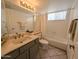 Bright bathroom featuring a tub, a large mirror, tile flooring, and a gray vanity at 4636 E Carmen St, Phoenix, AZ 85044