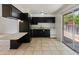 Charming kitchen featuring black cabinets, standard appliances and a sliding glass door at 524 W Fairway Dr # 9, Mesa, AZ 85201