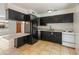 A well-lit kitchen featuring black cabinets, a breakfast bar and tile flooring at 524 W Fairway Dr # 9, Mesa, AZ 85201