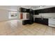 An open-concept kitchen featuring black cabinets, tile floors and white appliances at 524 W Fairway Dr # 9, Mesa, AZ 85201