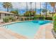 Outdoor pool with palm trees, a safety fence, and a sunny backyard, perfect for summer fun at 524 W Fairway Dr # 9, Mesa, AZ 85201