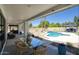 Inviting outdoor patio with comfortable seating, dining table, lush landscaping, and a sparkling pool view at 5430 E Shea Blvd, Scottsdale, AZ 85254