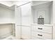 Walk-in closet featuring custom white shelving, drawers, and hanging rods at 5430 E Shea Blvd, Scottsdale, AZ 85254