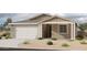 Charming single-story home features a tan exterior, a two-car garage, and desert landscaping at 5507 W Piedmont Rd, Laveen, AZ 85339