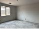 An unfinished room features smooth drywall, a window with views of the outdoors and concrete floors at 5507 W Piedmont Rd, Laveen, AZ 85339